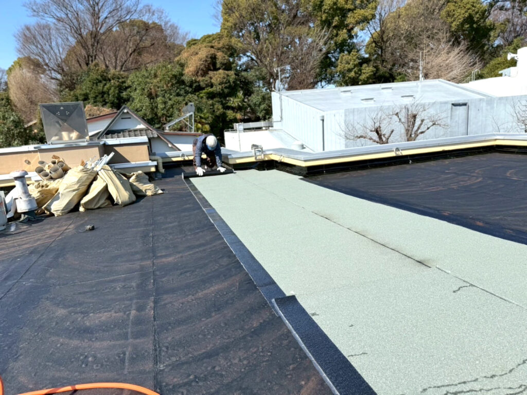 屋上にシート防水を施工しているところ